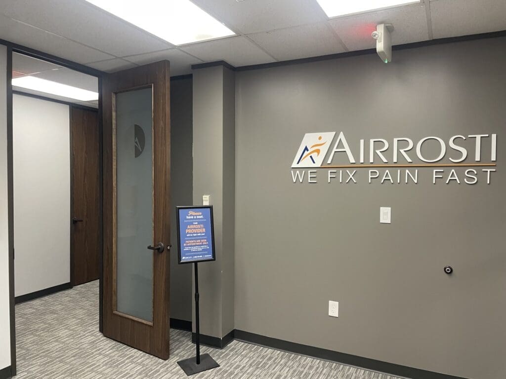 a view of the interior Airrosti The Woodlands lobby featuring the Airrosti Logo on the wall.